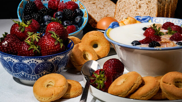 Colazione vegana. Still life di food con latte yogourt biscotti fragole frutti rossi  uova e pane, rappresentazione di colazioneme diterranea a base di alimenti sani
