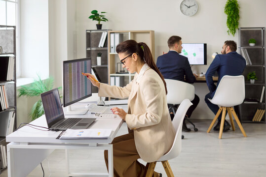 Business accountant woman performs audit using computer. In a bright office she analyzes finance data, prepares reports and checks compliance for clients. Clear financial analysis work concept.