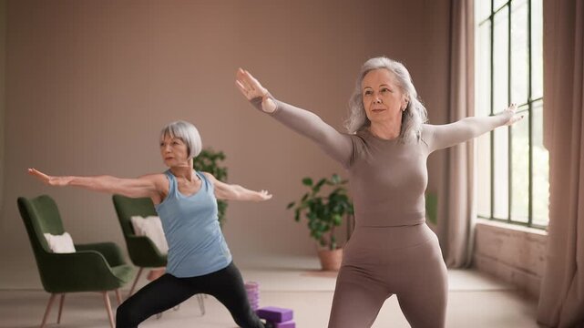Senior women friends practicing yoga exercises on mats, active healthy lifestyle