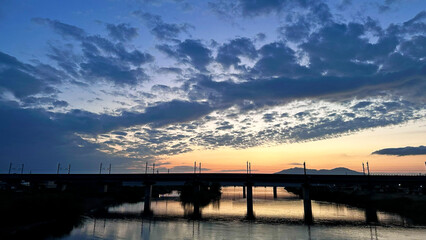 Obraz premium 新潟県燕市 中ノ口川の夕暮れ 佐渡橋から望む鉄道橋と美しい空の風景