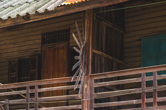 Old traditional wooden house balcony featuring unique sunburst wood carving decoration and designed to prevent people from climbing over balcony. Sunburst design by wood craft. Traditional lifestyle