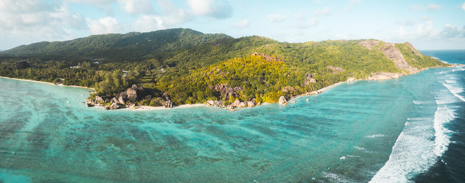 Aerial view of Anse Source d'Argent beach with iconic granite boulders, turquoise lagoon, and lush tropical vegetation in L'Union Estate, Seychelles.
