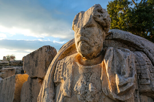 Statue of a man among the ancient ruins of Eleusis. Eleusis, Greece, January 2019