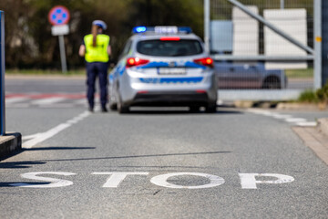 Policjantka kontroluje ruch drogowy pojazdów na drodze.  © FotoDax
