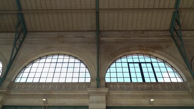 Massive arched windows of the historic Gare du Nord station in Paris, France.