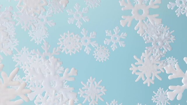 Snowflakes in different shapes fall gently from the top of the screen to the bottom. The background is a light blue color, creating a winter atmosphere. This animation shows the beauty of snow