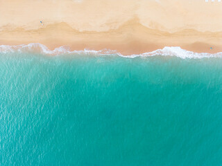 Aerial overhead view capturing the relaxing scene of blue ocean water gently washing onto a golden sand shore. Stock photo © Timur Abasov