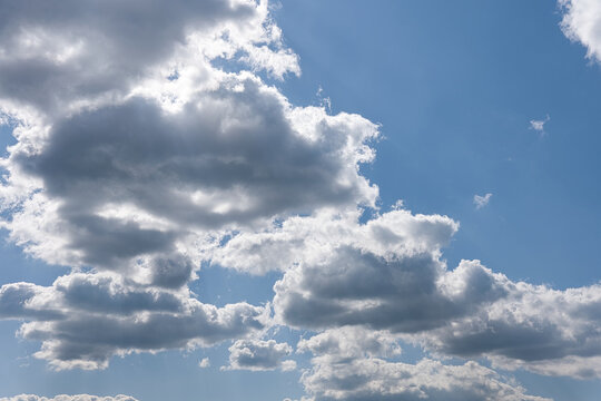 Helle Wolken ziehen vor der Sonne &uuml;ber einen blauen Himmel.