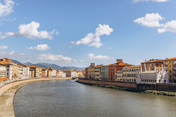 Fototapeta premium Arno river flowing through Pisa, Italy with historic buildings and Santa Maria della Spina chapel along the bank
