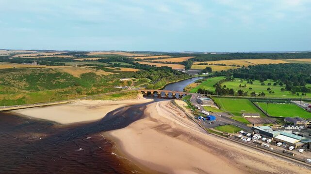 Aerial drone approach from Moray Firth sea to Banff Bridge and River Deveron, Aberdeenshire, Scotland