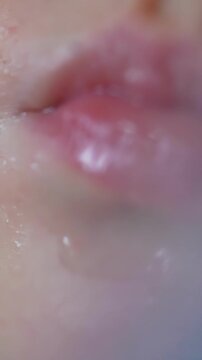 A close-up view of lips shows soft texture and subtle shine. highlights the natural beauty of the lips, focusing on their delicate details.