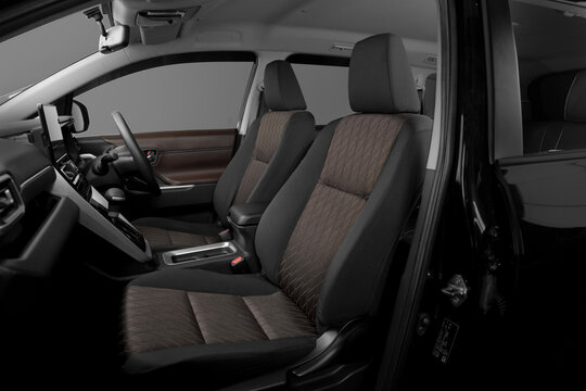 Modern car interior front row seats with premium brown two-tone fabric, diamond stitching pattern, and dashboard view. Right hand drive vehicle cabin inside.