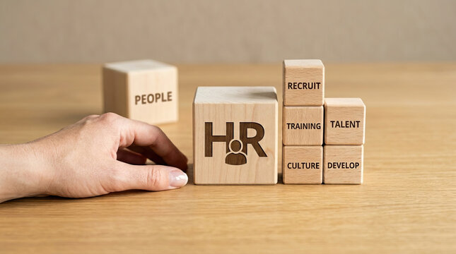 Human resource concept with wooden blocks showing HR, recruit, training, talent, culture, develop, and people on wooden table with hand arranging blocks