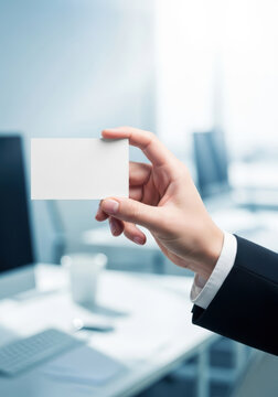 Clean hand holds white blank business card suit sleeve against blurred office background conveying professional introduction and confident