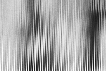 A grayscale image with vertical lines of varying shades and widths on a textured surface background © GraphixWave
