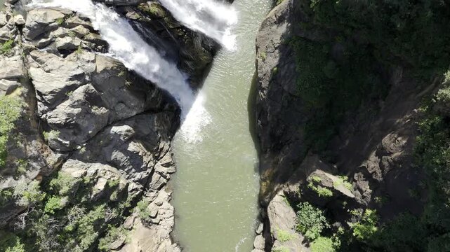 Drone flies west in bird's eye view of Mantenga waterfall on the Lusushwana River on a sunny day in Ezulwini, Eswatini