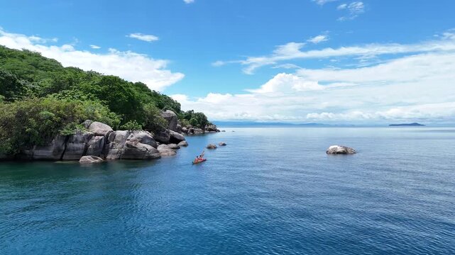 Two women kayaking on the crystal-clear waters of Lake Malawi, enjoying an active and adventurous day in a tropical setting.