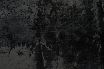 Fototapeta premium The texture of the old wall is rough and dark with faded paint.