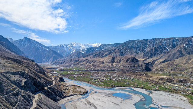 Aerial view of a mountain valley, river, and village in Chitral