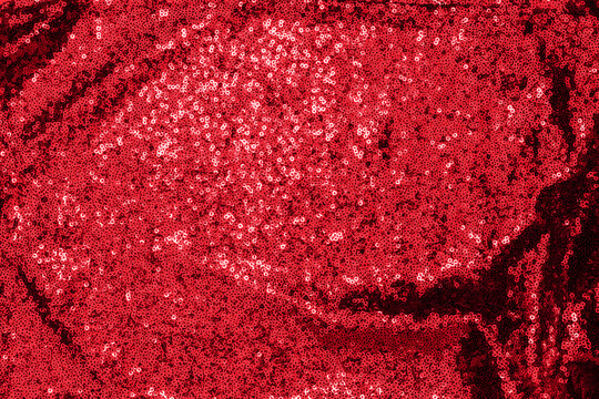 Bright red sequins create a shiny surface on fabric used for decoration and costumes at events or parties