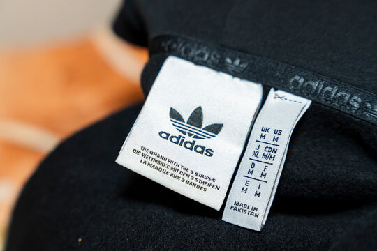 Warsaw, Poland - April 20, 2026: Close-up of an adidas clothing tag featuring brand information and size details, symbolizing authenticity and global fashion standards.