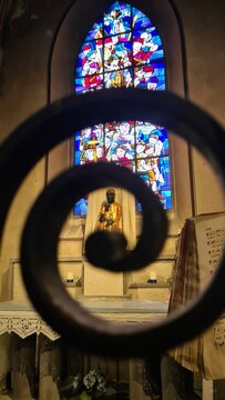 La Vierge Noire du sanctuaire Notre-Dame de Marsat (Auvergne) vue &agrave; travers les spirales m&eacute;talliques de la chapelle