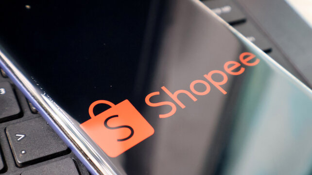 A close-up view of a laptop screen displaying the Shopee logo on a keyboard