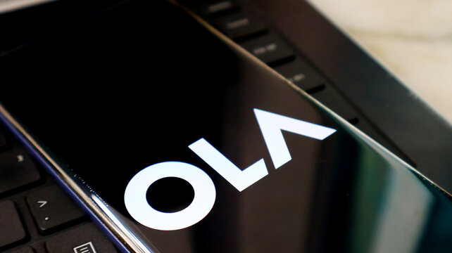 A close-up view of a laptop screen displaying the Ola logo prominently