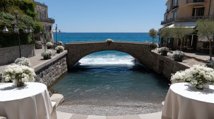 Obraz premium The bridge connects pathways near the sea, surrounded by bright flowers and water reflecting the clear sky on a sunny day