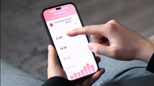 Successful travel blogger analyzing monthly income and channel growth on a mobile dashboard. High-converting footage of viral video stats and revenue metrics for influencer marketing and digital