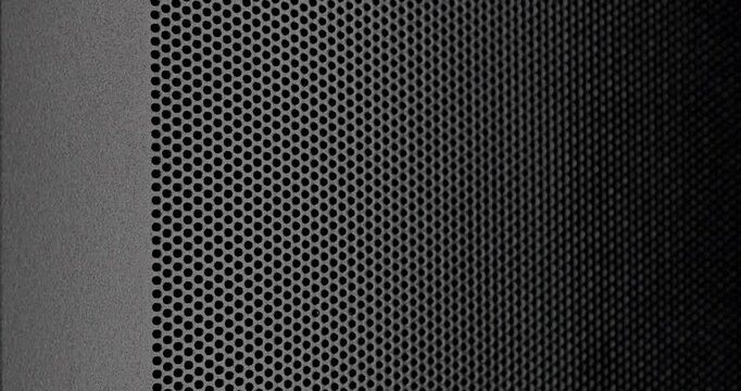 Perforated Metal Surface. A black perforated surface with a repeating pattern of holes creates a textured, industrial look.