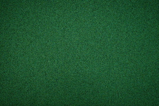 Bright green carpet covering a smooth surface in a room during daytime showing clear and clean texture
