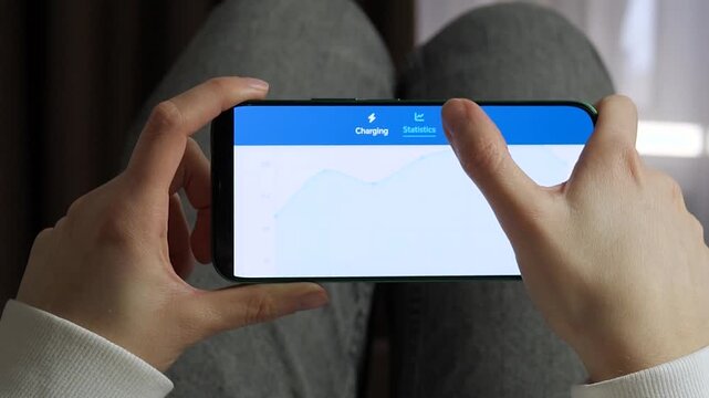 Manage electric vehicle battery life with a smart charging app. User sets charge limits to 90 percent and checks monthly energy consumption statistics. Ideal for green energy, sustainable transport