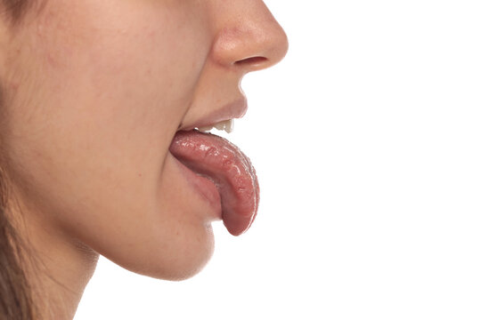 Side view close-up of a woman with tongue out showing mouth, teeth and tongue, medical oral health and anatomy concept on white background