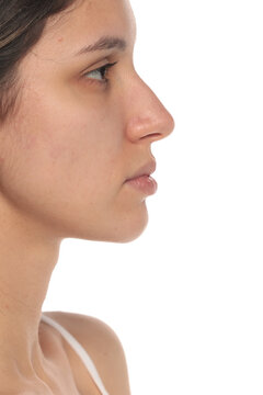 Side view close-up portrait of a woman&rsquo;s face with natural clean skin and no makeup, studio shot on a white background.