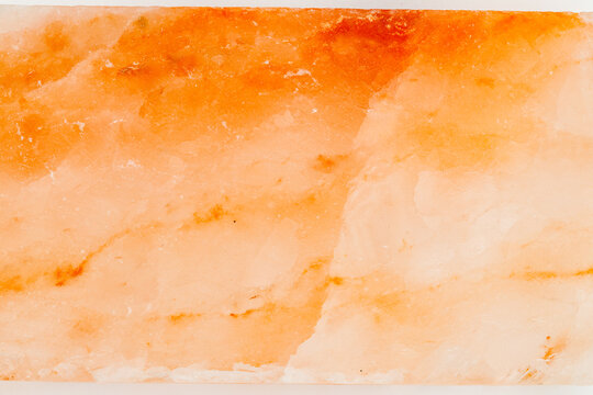 Orange salt block used for cooking on grill or in oven in kitchen setting