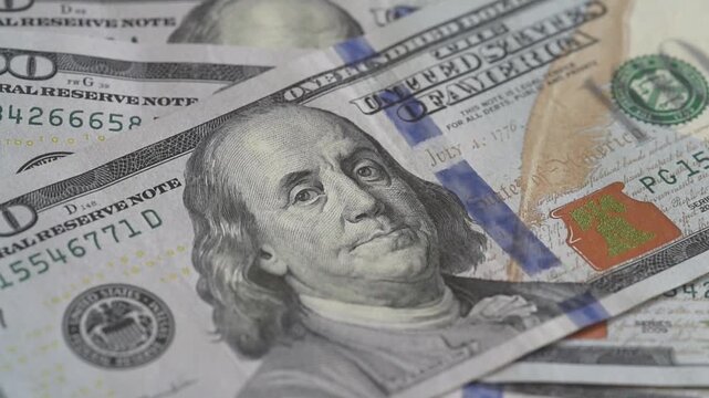 Counting $100 bills. Money being placed on a table, close-up on $100 bills. Zoom in effect.