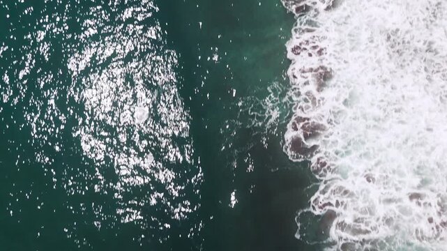 Aerial shot that pans from sea to the coastline