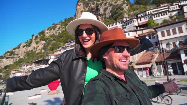 Portrait Joyful heterosexual couple looking at camera taking selfie photo laughing enjoying spring vacation get away holidays in Berat, Albania. Concept connection, happiness, freedom, fun, bonding