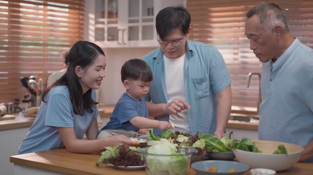 Happy multigenerational family preparing healthy meal together in kitchen, parents and grandfather bonding with child, fresh food and warm lifestyle concept