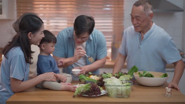 Happy multigenerational family preparing healthy meal together in kitchen, parents and grandfather bonding with child, fresh food and warm lifestyle concept