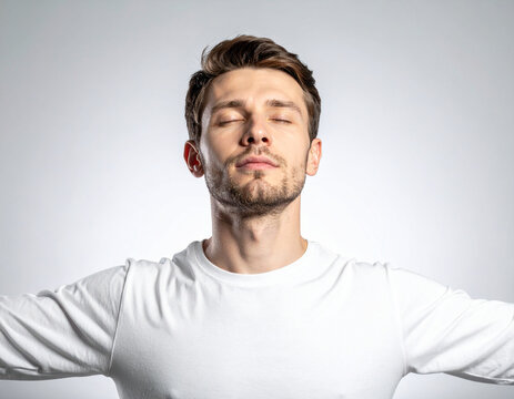white man with open arms and closed eyes in studio portrait symbolizing letting go and acceptance, white background