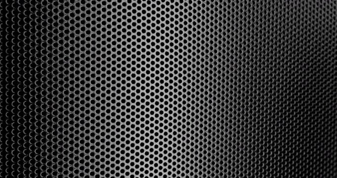 Perforated surface texture. Black perforated surface with a repeating hole pattern, creating a textured and industrial look.