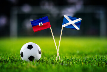 Obraz premium Haiti vs Scotland, national flags before world championship Group C group stage match, football on green pitch with goal in the background, Foxborough, USA, June 13, 2026