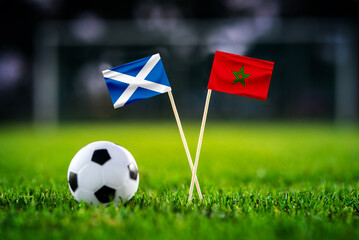 Obraz premium Scotland vs Morocco, national flags before world championship Group C group stage match, football on green pitch with goal in the background, Foxborough, USA, June 19, 2026