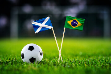 Obraz premium Scotland vs Brazil, national flags before world championship Group C group stage match, football on green pitch with goal in the background, Miami Gardens, USA, June 24, 2026