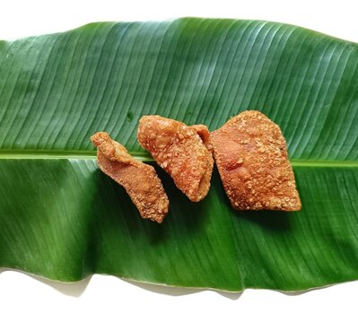 Traditional guatemalan pork rinds chicharrones on banana leaf musa x paradisiaca on white background