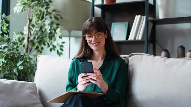 Video of female psychologist using smartphone while sitting on the couch in her consultation