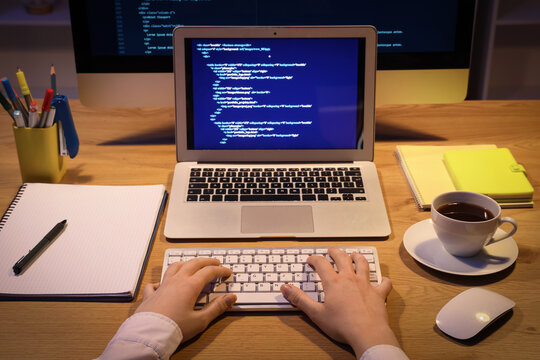Female programmer's hands working in office at night