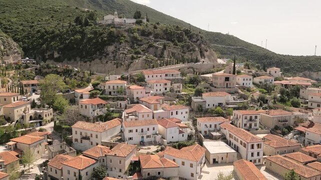 Stunning aerial footage historic Saint Mary Monastery or Kisha e Shen Merise perched atop the old village of Dhermi, overlooking traditional Dhermi stone houses